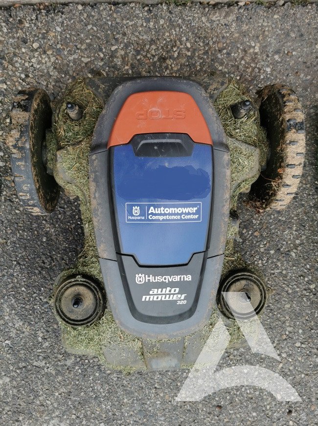 Robot tondeuse rempli d'herbe, terre et résidius