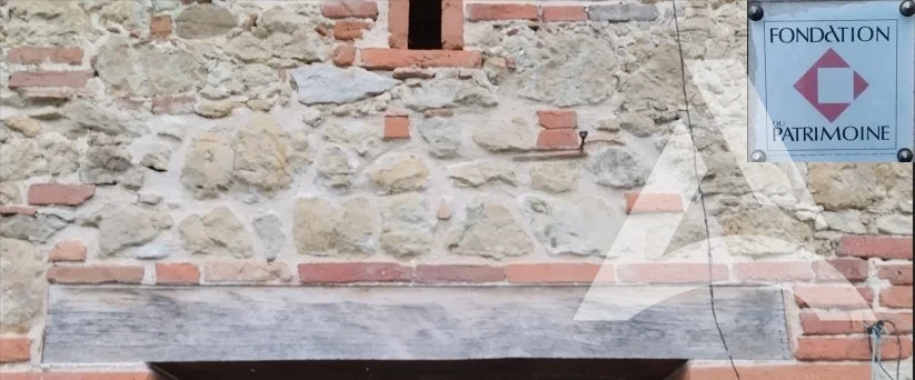 Poutre en chêne encrassée avant décapage sur façade en pierre