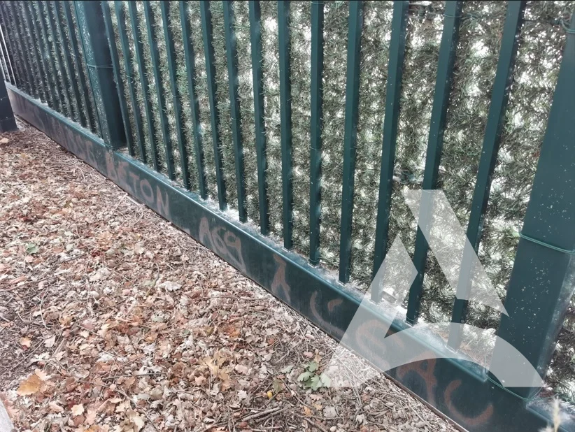 Portail métallique vert avec tag à la peinture aérosol