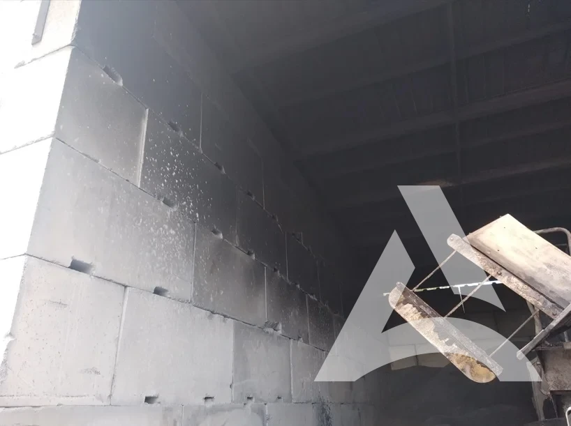 Hangar en béton encrassé par la suie après incendie