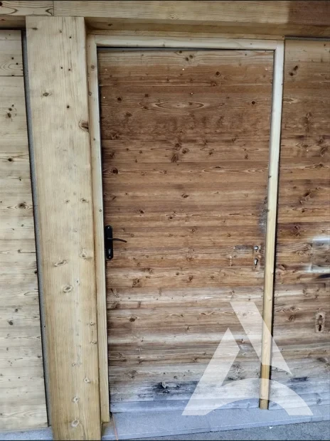 Porte de chalet en bois face ouest encrassée avant nettoyage avec traces d’humidité
