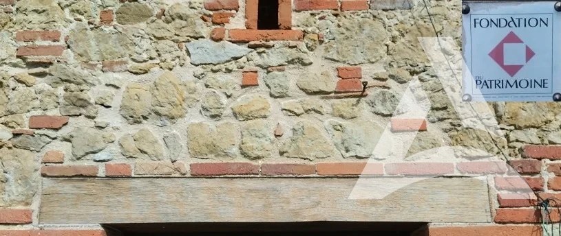 Poutre en chêne après décapage et nettoyage sur façade en pierre