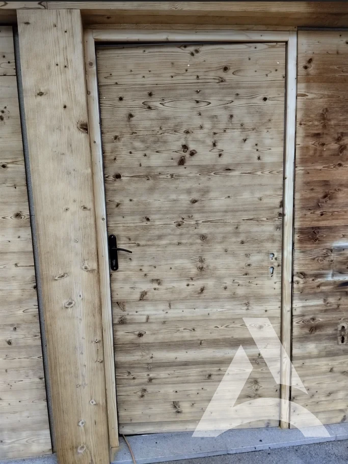 Porte de chalet en bois nettoyée face ouest avec bois éclairci et uniforme